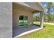 Covered patio with sliding glass door, table and chairs, and the reflection of the table is visible inside at 12212 Sw 90Th Pl, Dunnellon, FL 34432