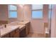 Bright bathroom featuring dual sinks, bathtub with tile surround, and a glass-enclosed shower at 12630 Old Plantation Ln, Orlando, FL 32824