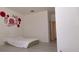 Minimalist bedroom featuring light wood laminate flooring, a decorative wall and adjacent hallway at 12630 Old Plantation Ln, Orlando, FL 32824