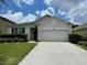 Well-maintained single-story home featuring a two-car garage, lawn, and mature landscaping at 12630 Old Plantation Ln, Orlando, FL 32824