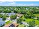 Aerial view of a charming single-story home with a lush green yard, shaded by mature trees near a serene pond at 13943 Caywood Pond Dr, Windermere, FL 34786