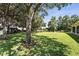 Expansive backyard with mature trees, pond, lush green lawn and black metal perimeter fencing at 13943 Caywood Pond Dr, Windermere, FL 34786