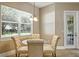 Cozy dining area with a round glass table, upholstered chairs, and a view to the backyard at 13943 Caywood Pond Dr, Windermere, FL 34786