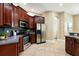 Well-equipped kitchen with stainless steel appliances, wooden cabinetry, and tiled flooring at 13943 Caywood Pond Dr, Windermere, FL 34786