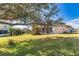 Expansive backyard featuring lush green grass and mature trees, offering a serene outdoor space at 1425 Hollyberry Pl, The Villages, FL 32162