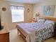 Cozy bedroom with floral bedding and bright natural light from the window at 1425 Hollyberry Pl, The Villages, FL 32162