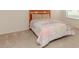 Cozy bedroom with a patterned quilt bedspread and carpeted floors at 1425 Hollyberry Pl, The Villages, FL 32162