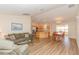 Open concept living space with wood floors that flows into the kitchen and dining area at 1425 Hollyberry Pl, The Villages, FL 32162