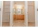 Walk-in closet leading to a bathroom with double sinks and a glass shower at 1425 Hollyberry Pl, The Villages, FL 32162