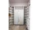 Custom closet with white shelves, cabinets, and a mirrored wardrobe for optimal storage and style at 15071 Guava Bay Dr, Winter Garden, FL 34787