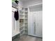 Custom closet with white shelves, cabinets, and a mirrored wardrobe provides style and optimal storage at 15071 Guava Bay Dr, Winter Garden, FL 34787