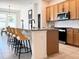 Stylish kitchen featuring a large island with seating, granite countertops, and stainless steel appliances at 15071 Guava Bay Dr, Winter Garden, FL 34787