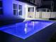 Backyard pool illuminated by blue lighting with seating area at 15071 Guava Bay Dr, Winter Garden, FL 34787