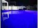 Backyard pool illuminated by blue lighting, with patio furniture at 15071 Guava Bay Dr, Winter Garden, FL 34787