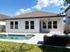 Bright rear exterior view featuring a pristine pool, covered patio, and a modern architectural style at 15071 Guava Bay Dr, Winter Garden, FL 34787