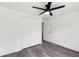 This bright bedroom features a ceiling fan, closet, and sleek, gray laminate flooring at 18015 Beach St, Umatilla, FL 32784
