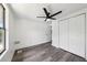 This bright bedroom features a ceiling fan, closet, and sleek, gray laminate flooring at 18015 Beach St, Umatilla, FL 32784