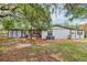 Back exterior of a bright home featuring trees, deck and new air conditioner at 18015 Beach St, Umatilla, FL 32784