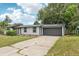 Beautifully renovated house featuring black trimmed windows, a two-car garage, and mature trees at 18015 Beach St, Umatilla, FL 32784
