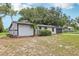 Landscaped single-story home featuring black trimmed windows and mature trees at 18015 Beach St, Umatilla, FL 32784