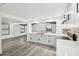 Modern kitchen with white cabinets, marble countertops, stainless steel appliances, and gray wood-look flooring at 18015 Beach St, Umatilla, FL 32784