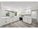Modern kitchen with white cabinets, marble countertops, stainless steel appliances, and gray wood-look flooring at 18015 Beach St, Umatilla, FL 32784