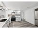 Modern kitchen with white cabinets, stainless steel appliances, and gray wood-look flooring at 18015 Beach St, Umatilla, FL 32784