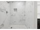 Renovated shower with tile walls, shower niche, and decorative tile floor at 18015 Beach St, Umatilla, FL 32784