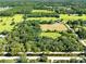 Sprawling aerial view of grassy fields and trees with scattered homes in a rural setting with a clear sky at 187 N Samsula Dr, New Smyrna Beach, FL 32168