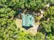 Aerial view showcases a green-roofed cabin nestled among trees offering privacy and seclusion at 187 N Samsula Dr, New Smyrna Beach, FL 32168