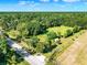 Scenic aerial view of property featuring a lush, wooded landscape and country road frontage at 187 N Samsula Dr, New Smyrna Beach, FL 32168