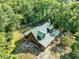 Birds eye view of green roofed home enveloped by a dense, vibrant tree canopy at 187 N Samsula Dr, New Smyrna Beach, FL 32168