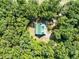 Overhead view of green roofed home nestled amongst mature trees at 187 N Samsula Dr, New Smyrna Beach, FL 32168