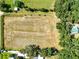 Aerial view of a large, cleared and fenced lot with mature trees at 187 N Samsula Dr, New Smyrna Beach, FL 32168