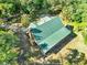 Aerial view showcases a charming home with a metal roof surrounded by lush trees at 187 N Samsula Dr, New Smyrna Beach, FL 32168