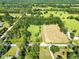 Aerial view capturing a mix of open fields and tree cover with a home and barn at 187 N Samsula Dr, New Smyrna Beach, FL 32168