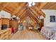 Lofted bedroom with A-frame ceiling, stone accent wall, and comfortable seating area at 187 N Samsula Dr, New Smyrna Beach, FL 32168