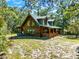 Cozy log cabin with a spacious porch nestled amidst a serene natural setting at 187 N Samsula Dr, New Smyrna Beach, FL 32168