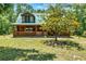 Inviting log cabin featuring a covered porch and serene natural surroundings at 187 N Samsula Dr, New Smyrna Beach, FL 32168