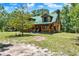 Charming log cabin with a green metal roof and welcoming front porch at 187 N Samsula Dr, New Smyrna Beach, FL 32168