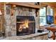 Cozy stone fireplace with a wooden mantle and a protective fire screen in the living room at 187 N Samsula Dr, New Smyrna Beach, FL 32168
