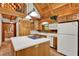 Charming kitchen with wooden cabinets, island cooktop, and stainless steel appliances under a vaulted ceiling at 187 N Samsula Dr, New Smyrna Beach, FL 32168