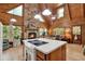 Bright living room and kitchen featuring a stone fireplace, vaulted ceilings, and open floor plan at 187 N Samsula Dr, New Smyrna Beach, FL 32168