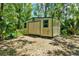 Utility shed with double doors and two windows, set within a grassy, shaded yard at 187 N Samsula Dr, New Smyrna Beach, FL 32168