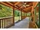 Wide porch with wooden beams, ceiling fans, and comfortable seating overlooking the yard at 187 N Samsula Dr, New Smyrna Beach, FL 32168