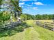 Picturesque driveway framed by wooden fences leading to a beautiful green property at 187 N Samsula Dr, New Smyrna Beach, FL 32168
