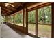 A screened porch with views of the outdoors, featuring wood columns and a ceiling fan at 187 N Samsula Dr, New Smyrna Beach, FL 32168