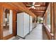 Spacious screened porch showcasing wood walls, ceiling fans, and refrigerators for outdoor living at 187 N Samsula Dr, New Smyrna Beach, FL 32168