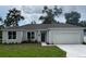 Charming single-story home with a gray roof, a freshly-poured white driveway, and a well-manicured lawn at 1889 15Th St, Orange City, FL 32763