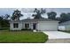 Charming single-story home with a gray roof, a freshly-poured white driveway, and a well-manicured lawn at 1889 15Th St, Orange City, FL 32763